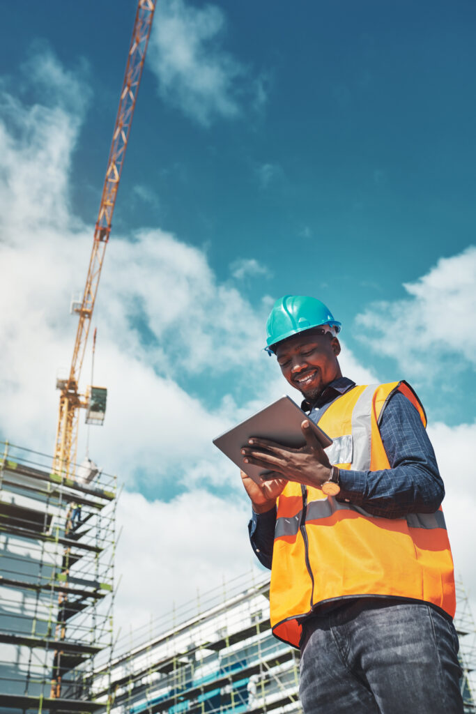 Engineer man, construction and a tablet for project management, development and architecture. Happy African male contractor with mobile app for engineering and safety inspection or planning outdoor.