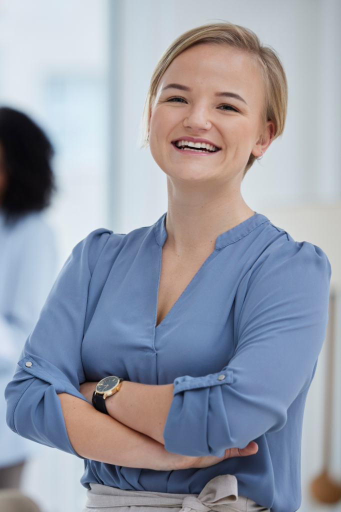 Portrait of woman standing smiling with arms folded